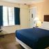 Passport Inn and Suites - Middletown guest room with king bed, window and bedside lamp