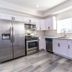 Green Homestay in Los Angeles kitchen with stainless steel appliances and stacked washer-dryer