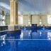 The Dilly in London indoor pool with blue-lit water, columns and arched windows