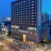 Amanti Hotel Seoul Hongdae exterior at dusk in Seoul with lit windows and city skyline