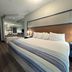 AmericInn by Wyndham Galesburg guest room with king bed, striped bedding and mirrored wall