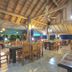 OYO 75353 Loy Chalet Resort in Nakhon Si Thammarat, open-air thatched dining area with wooden tables