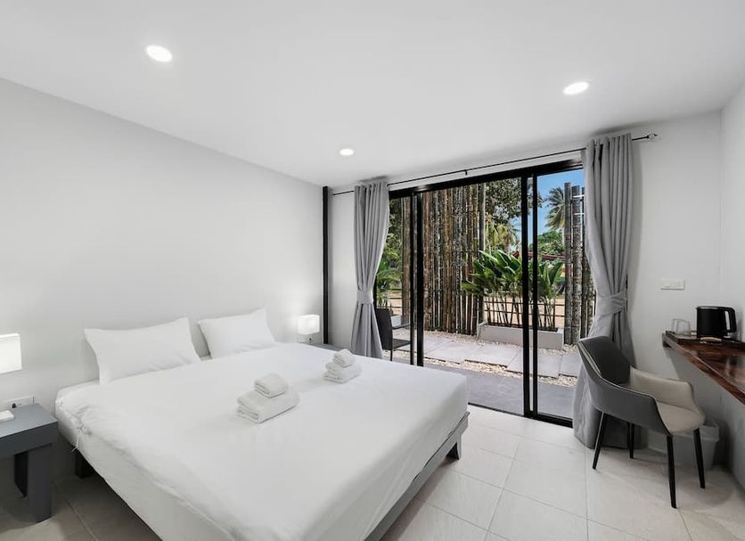 The Villager Fishermans Village in Ko Samui guest room with king bed and sliding doors to balcony