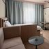 Sky Hotel Apartments Stockholm room with bed, sofa, TV, desk, and large window in Stockholm