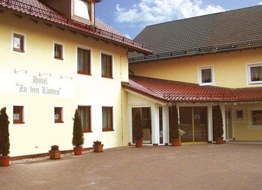 Zu den Linden Nichtraucherhotel in Aschheim exterior courtyard with yellow facade and red-tiled roof