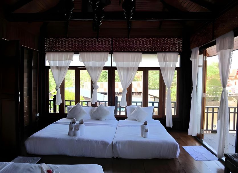At Casa Guesthouse Amphawa bedroom with twin beds and balcony views in Amphawa