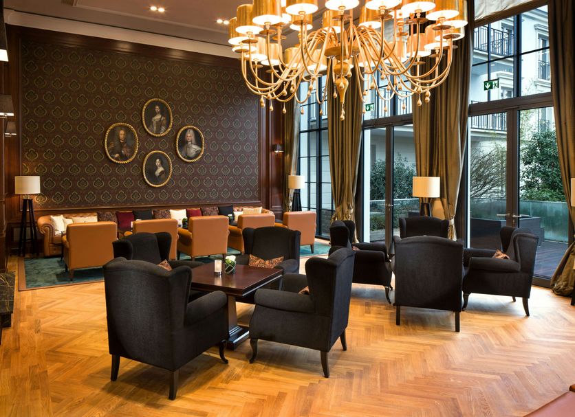 Hilton Frankfurt Gravenbruch lounge in Neu Isenburg with chandelier, armchairs, and floor-to-ceiling windows