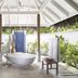 Anantara Dhigu Maldives Resort spa bath pavilion with freestanding tub, tropical greenery and waterfall shower