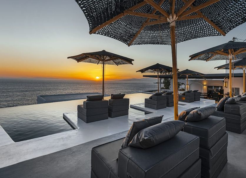 Tagoo Black Mykonos rooftop infinity pool and lounge seating at sunset overlooking the sea