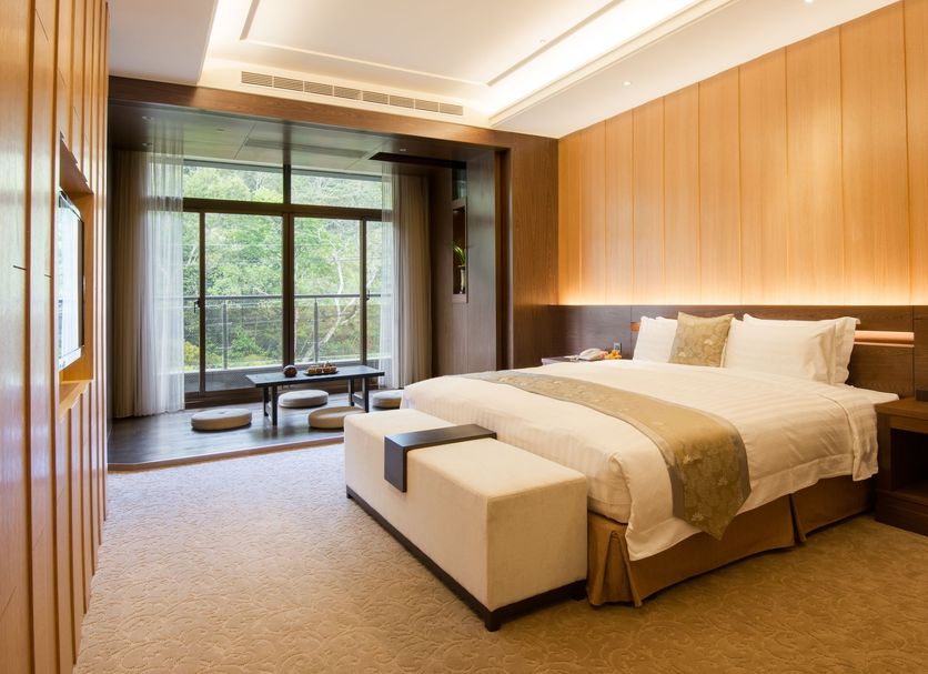 Fuli Hot Spring Resort in Yuchi Township guest room with king bed, bench, and large window view