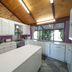 Blickinstal Holiday Retreat kitchen in Tanunda with island bench, white cabinets and window view