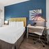 SureStay by Best Western Santa Monica guest room with bed, desk, chair and blue accent wall