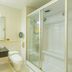Zuiranju Holiday Hotel in Zhaoqing bathroom with glass shower, sink vanity, and toilet