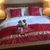 Newsham Grange Farm Thirsk bedroom with double bed, red bedding, bedside lamps and breakfast tray