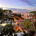 Onomo Hotel Rabat Terminus rooftop view over Rabat at sunset with palm-lined street and city buildings