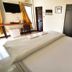 Bangrak Resort in Nakhon Sawan guest room with bed, wall-mounted TV, desk, and wardrobe