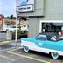 Coastal Inn and Suites in Long Beach, with a vintage turquoise car parked outside the entrance
