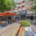 Outdoor terrace at Boutique Hotel Corona in The Hague with picnic tables and orange umbrellas