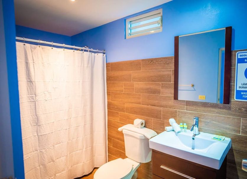 El Navegante de Culebra bathroom with shower curtain, sink, toilet and blue walls in Culebra.