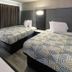 Motel 6 Meridian MS guest room with two beds and modern gray wall paneling