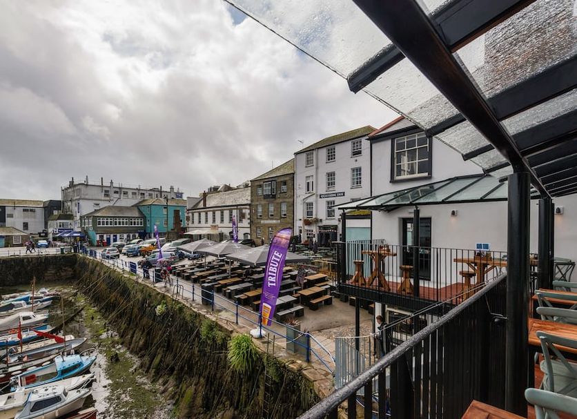 Chainlocker, Falmouth: harbor view with boats, waterside terrace seating, and cloudy sky