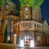 Sozo Hotel in Nantes, lit historic stone church exterior with tall stained-glass windows at night