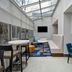 Hampton Inn New York-JFK in Queens lounge with glass ceiling, seating area, tables, and wall-mounted TV