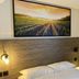 The Originals City, Angers Sud, Le Village 49 room with bed, headboard, wall lamp and vineyard artwork