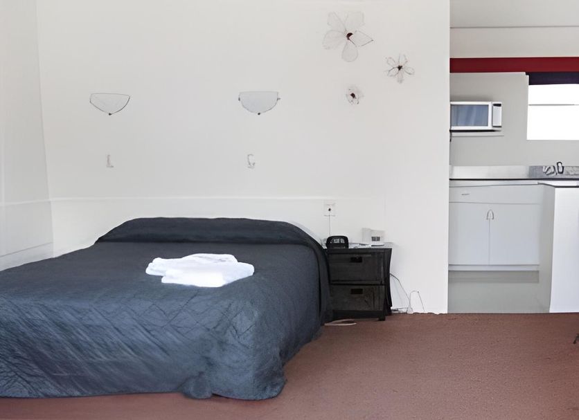 Midtown Motor Inn Whanganui room with queen bed, bedside table and kitchenette