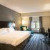 The Mosey Buffalo Williamsville guest room with king bed, desk, chair, TV and window seating