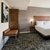 Courtyard by Marriott Los Angeles Sherman Oaks guest room with king bed, bench, and balcony view