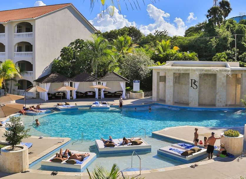 Presidential Suites by Lifestyle, Puerto Plata: outdoor pool with loungers and cabanas beside resort buildings