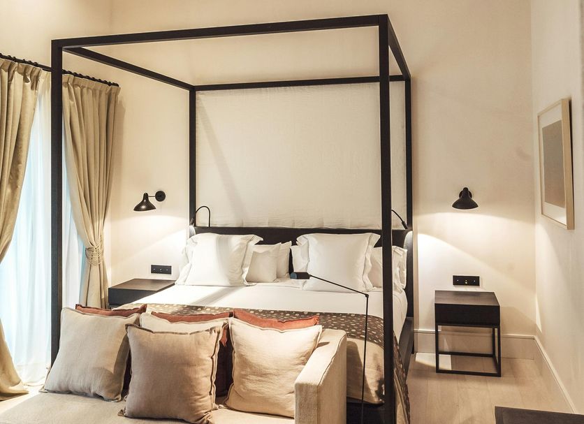 Sant Francesc Hotel Singular in Palma de Mallorca, modern four-poster bedroom with sofa and balcony curtains