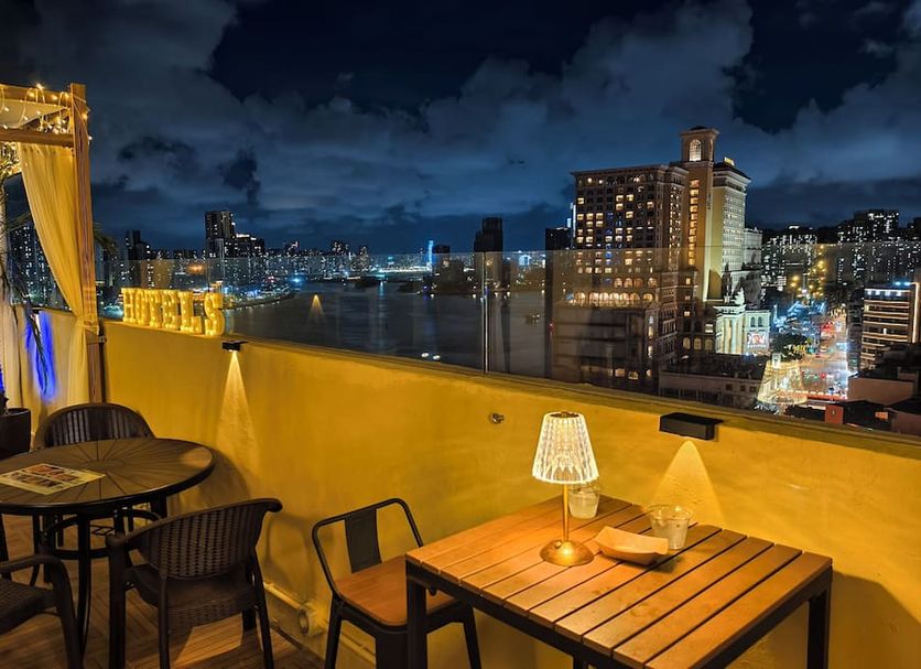 Macau Hotel S rooftop terrace with tables and city skyline views in Macau at night