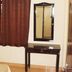 MM Tourist Home, Kāsaragod guest room with bed, desk, mirror and brown curtains