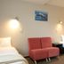 Bella Vista Motel Kaikoura room with two beds, red chair, and wall art in Kaikoura