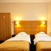 La Petite Apartments & Rooms in Gdansk: twin beds in a simple hotel room with warm lighting and window curtains