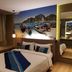 Bizotel Premier Hotel & Residence Bangkok guest room with bed, bay window seat and boat wall art