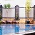 Swiss-Belhotel Borneo Samarinda pool with lounge chairs and potted palms in Samarinda