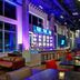 Aloft Seattle Redmond bar lounge with high-top tables, colorful seating and neon-lit interior
