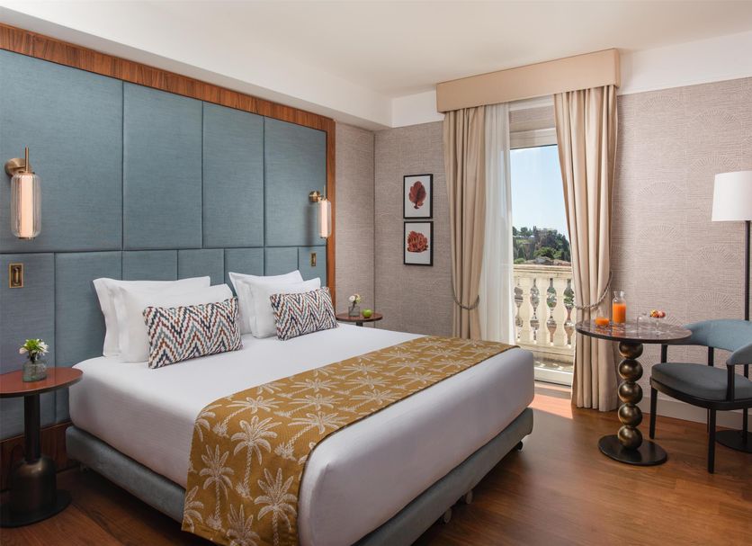 NH Collection Taormina guest room with king bed and balcony view in Taormina