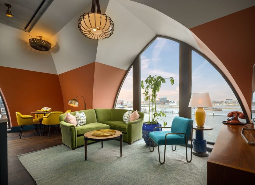 The July - Boat & Co in Amsterdam lounge with arched waterfront window and green sofa