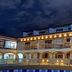 Hotel Gran Sirius in Sachica, lit-up colonial-style facade with arched balconies at night