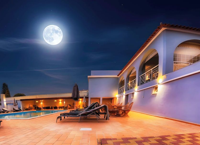 Villa Welwitshia in Praia do Carvoeiro, moonlit pool terrace with lounge chairs beside the hotel