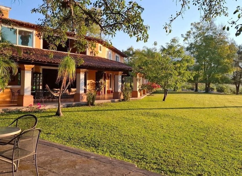Hotel Villa Cantabria in Mascota with a large lawn, shaded patio, and hammocks beside the building