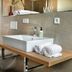 Hotel Das Regensburg bathroom with walk-in shower, wall-mounted sink, and folded towels in Regensburg