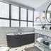 Cape Cadogan Boutique Hotel in Cape Town bathroom with freestanding tub, double vanity, round mirror and tiled walls