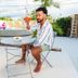 Romeo Hotel in San Juan: man seated on a patio holding a cocktail beside a round table and pool