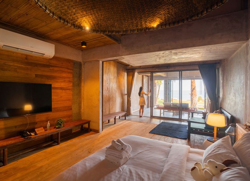 La A Natu Sam Roi Yot room with king bed, TV, and balcony view in Hua Hin