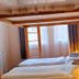 Dorf.Apart in Neustift im Stubaital bedroom with two single beds and warm wood framing